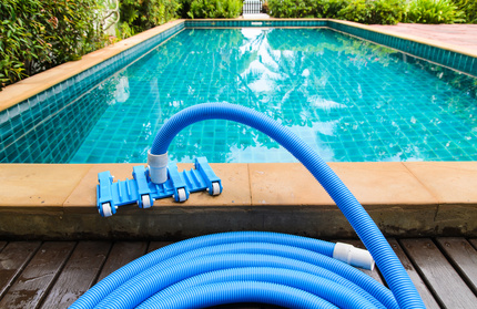 Pool vacuum cleaning flexible hose on the pool